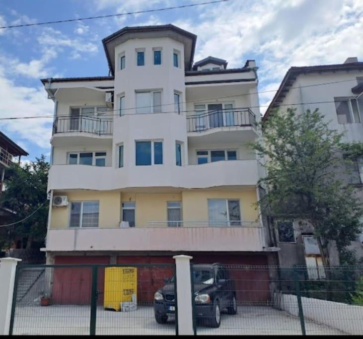 a building with a car parked in front of it at White House Apartments in Haskovo