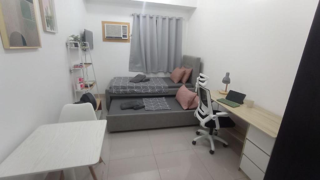 - un modèle de chambre avec un lit et un bureau dans l'établissement HOMELY Green 2 residences DLSU EAC UMC, à Dasmariñas