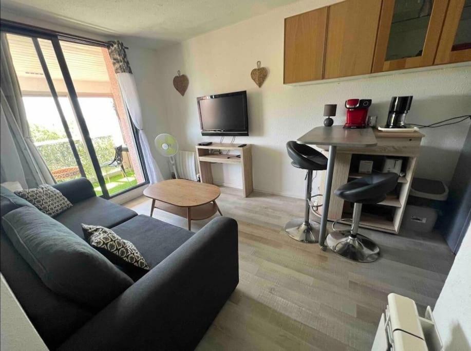 un salon avec un canapé, une table et un bureau dans l'établissement Élégant T2 près du port et de la plage Cap d'Agde, au Cap d'Agde