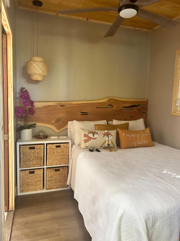 a bedroom with a white bed with a wooden headboard at Sweet Tiny Cabin in Tampa