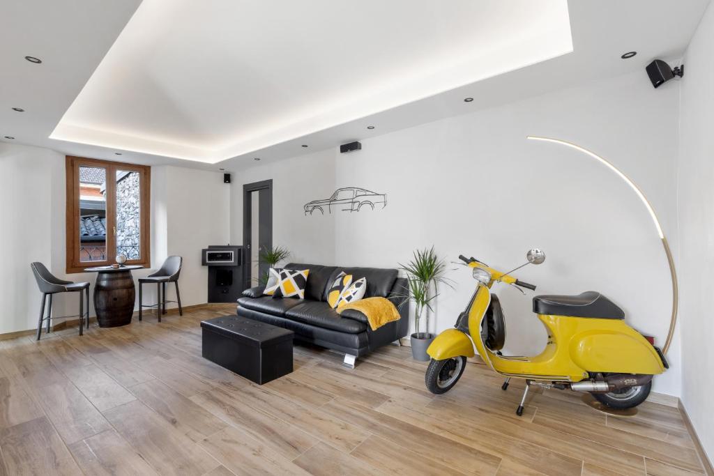 scooter amarillo en la sala de estar con sofá en LOFT 73 en Cannobio