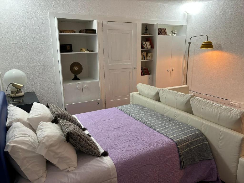 um quarto com uma cama com um cobertor roxo em TROIAMAR em Tróia