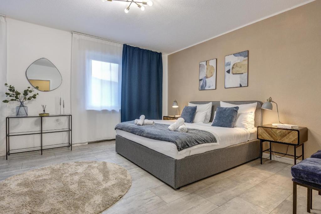a bedroom with a large bed with blue curtains at Zentrale Design Wohnung in Ufernähe - 105 qm - Parkplatz - Küche - Netflix in Bingen am Rhein