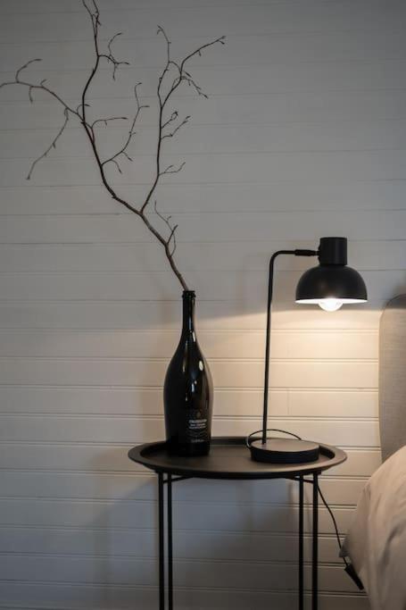 a lamp and a vase on a table next to a bed at Lovely house with courtyard and terrace near canal du Midi in Trèbes