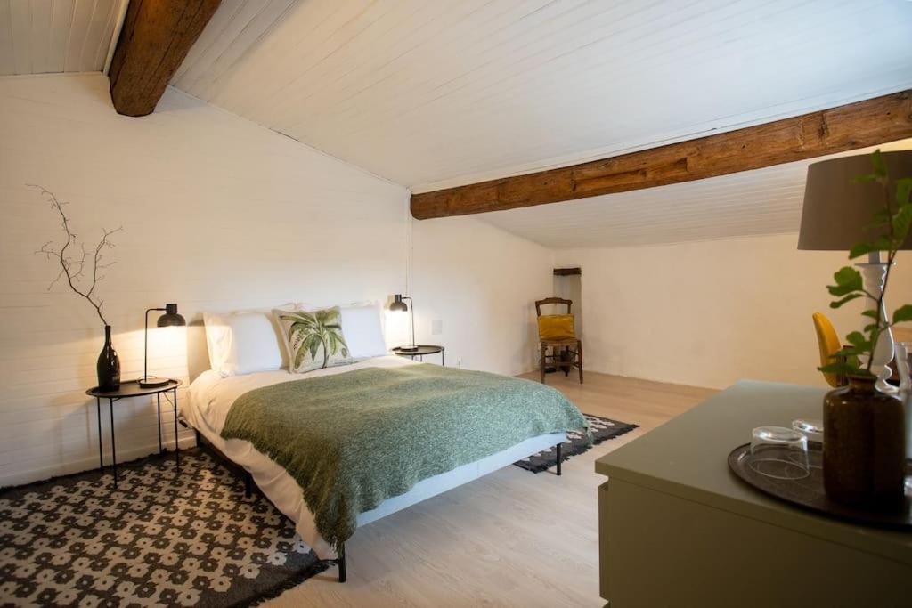 a bedroom with a large bed and a table at Lovely house with courtyard and terrace near canal du Midi in Trèbes
