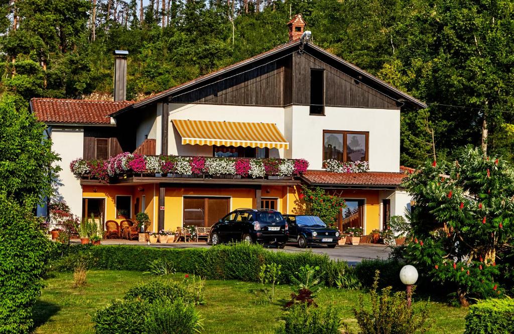 una casa con dos coches estacionados frente a ella en Guesthouse Sanabor en Postojna