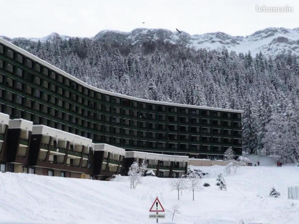a building in the snow in front of a mountain at Résidence Les Glovettes - Studio pour 4 Personnes 954 in Villard-de-Lans