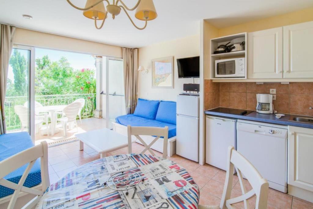 kuchnia i salon ze stołem i krzesłami w obiekcie Résidence le Hameau des Issambres - maeva Home - Studio 5 Personnes - Sélection MAE-5969 w mieście Les Issambres