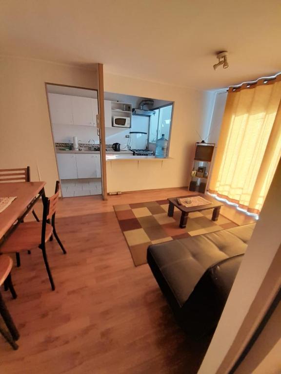 ein Wohnzimmer mit einem Bett, einem Tisch und einer Küche in der Unterkunft Departamento vallenar in Vallenar