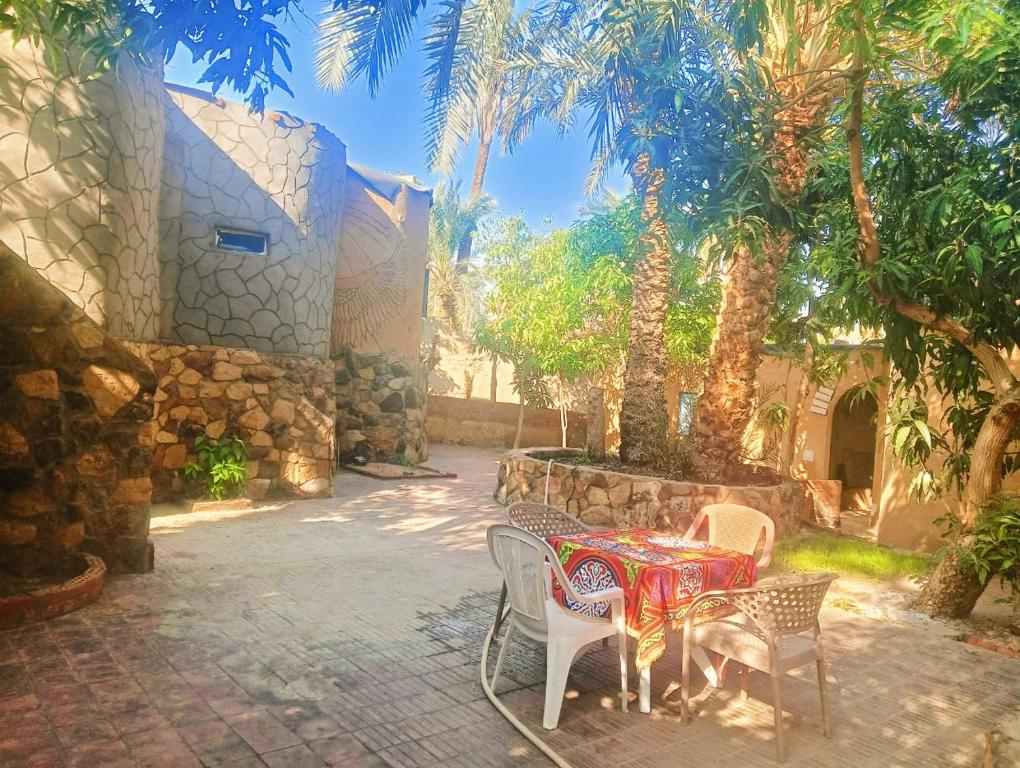 a patio with a table and chairs and palm trees at New Oasis in Bawati