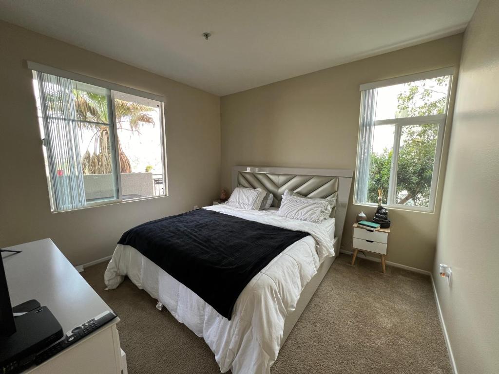 a bedroom with a large bed with two windows at Playa Vista Bedroom Retreat! in Glendale