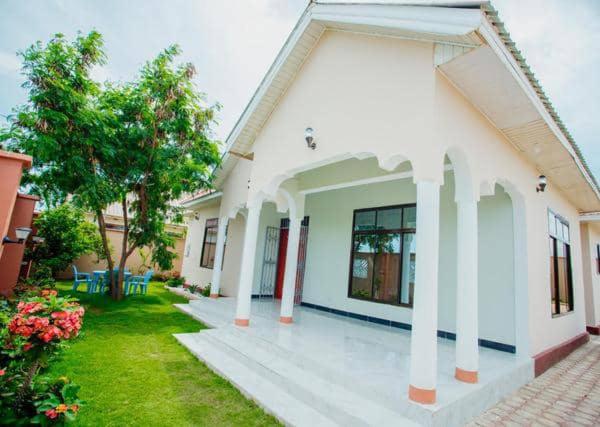 una casa blanca con columnas y un patio en Safi House, en Boma la Ngombe