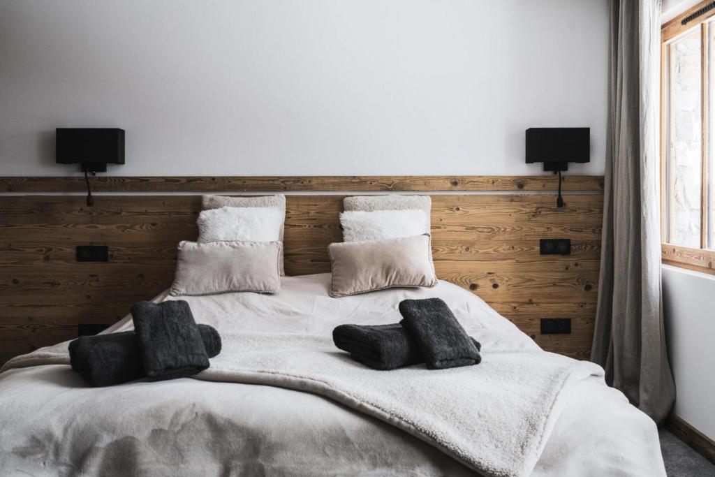 a bedroom with a large white bed with pillows at Résidence Le Bercail - Chalets pour 12 Personnes 224 in Saint-Martin-de-Belleville