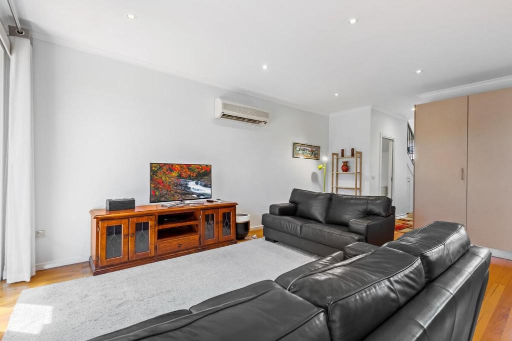 a living room with a couch and a tv at Nice & Quiet 2-Bed by Shops & Airport in Melbourne