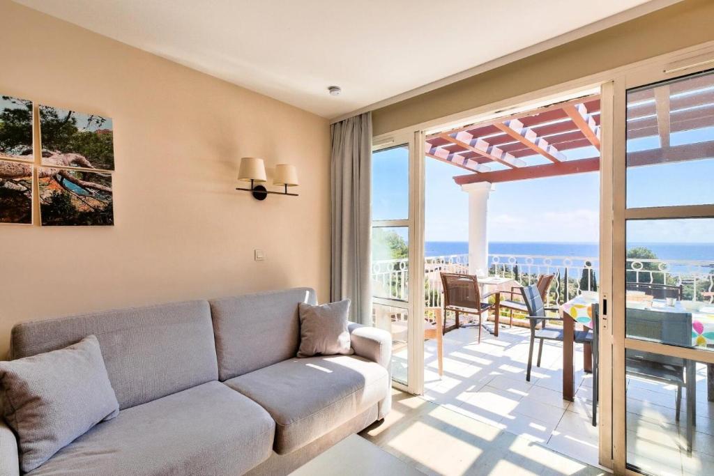 a living room with a couch and a view of the ocean at Résidence le Village de Cap Esterel - maeva Home - Appartement 2 pièces 6 p 26 in Saint-Raphaël