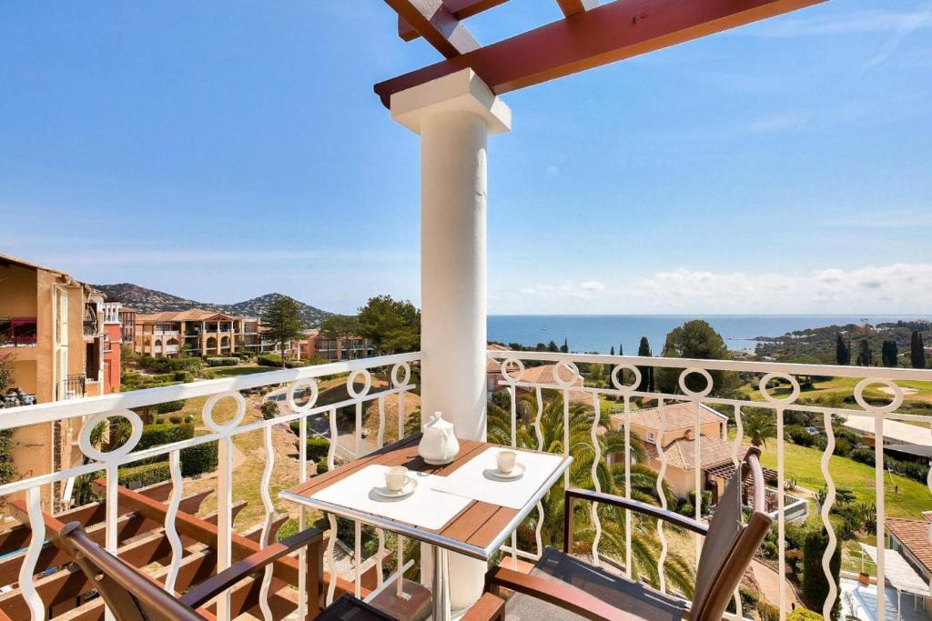 a balcony with a table and chairs and the ocean at Résidence le Village de Cap Esterel - maeva Home - Appartement 2 pièces 6 p 26 in Saint-Raphaël