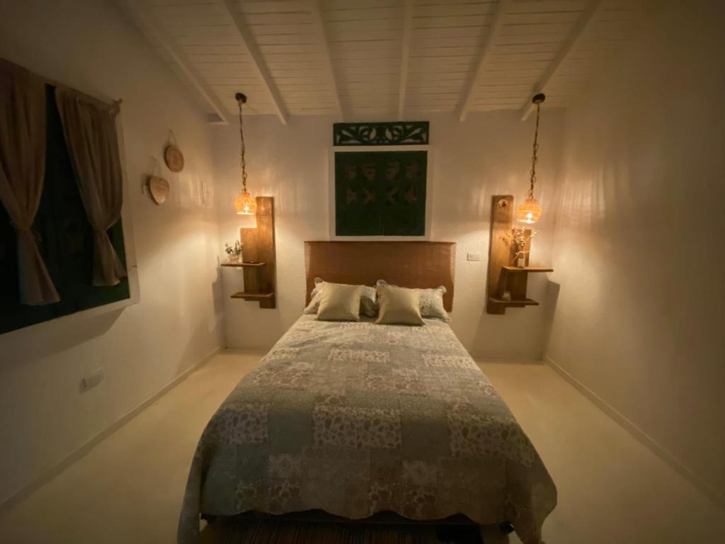a bedroom with a bed with two pillows on it at Villa Mohana in Puerto Colombia