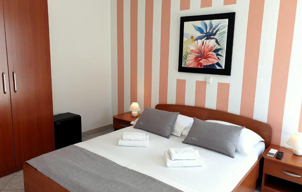 a bedroom with a bed with two towels on it at Sunset Split Rooms in Podstrana