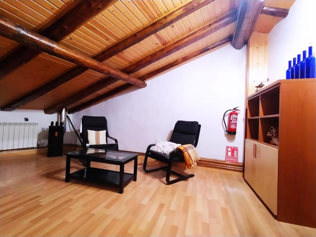 una habitación con 2 sillas y una mesa. en Casa Rural La Maestra, en Sigüés