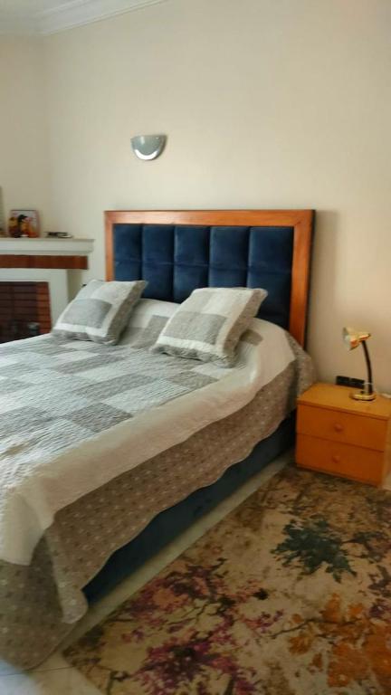 1 dormitorio con 1 cama grande y cabecero azul en Logement calme très proche du centre, en Oujda