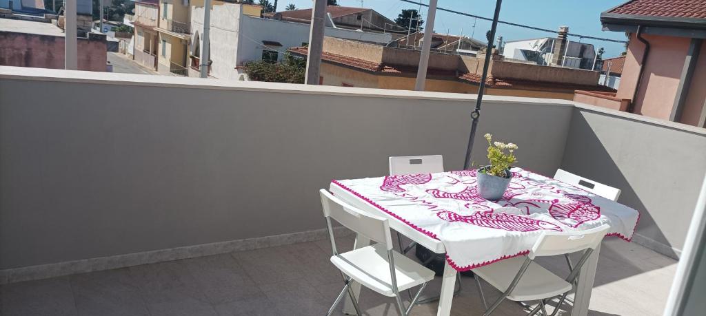 une table et des chaises assises sur un balcon dans l'établissement La Dimora del Sole - Casuzze, à Villaggio Azzurro
