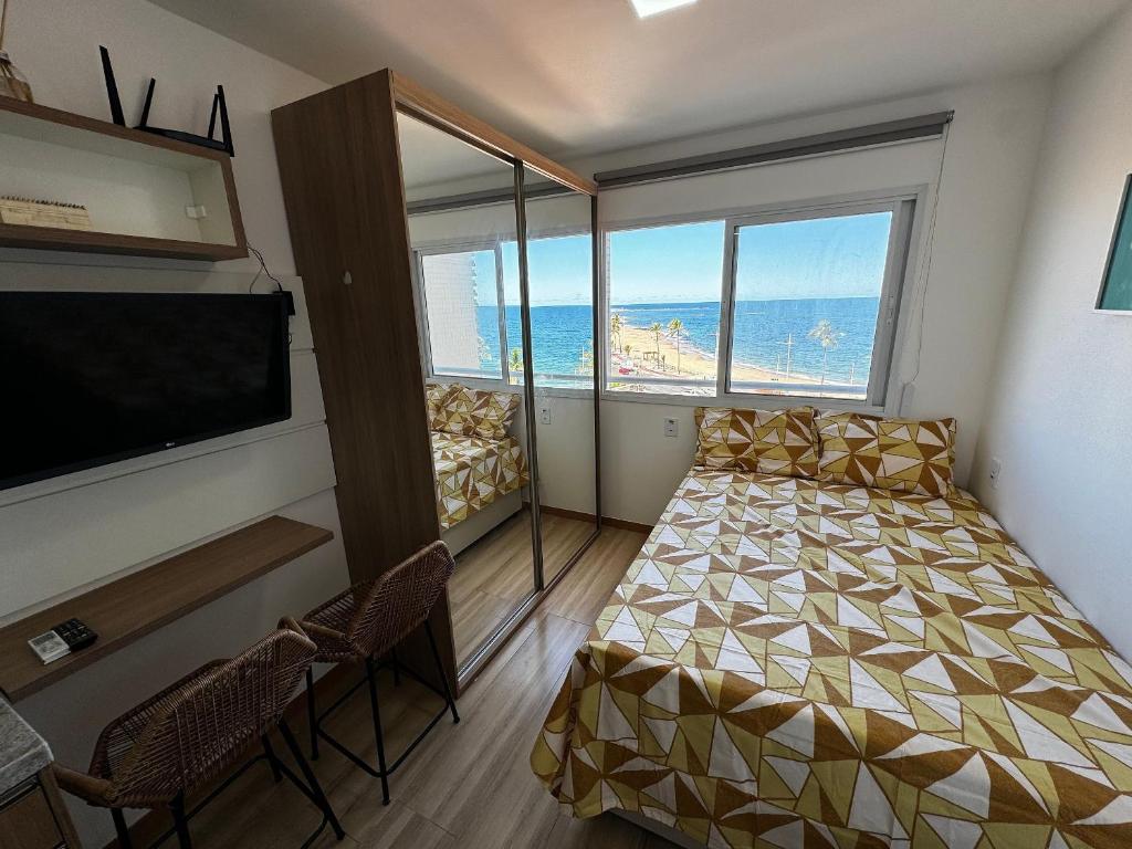 Cette petite chambre comprend un lit et une grande fenêtre. dans l'établissement Studio Aconchegante com vista mar no Smart Pituba, à Salvador