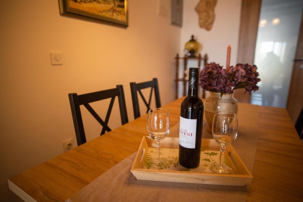 een fles wijn en twee wijnglazen op een tafel bij Apartment Sasa in Kaštela