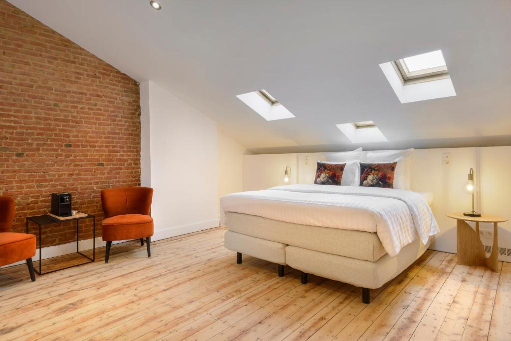 1 dormitorio con cama y pared de ladrillo en Our Bird's Nest in the Heart of Antwerp en Amberes