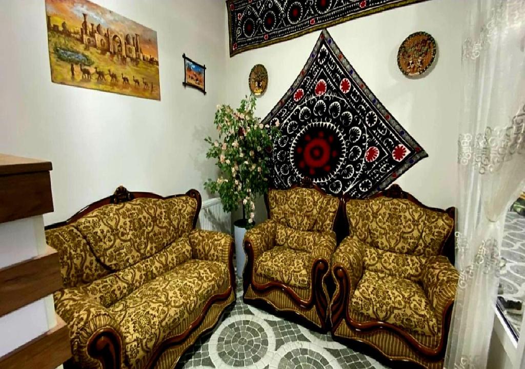 a living room with two couches and a wall at Alifa Lux Guesthouse in Samarkand