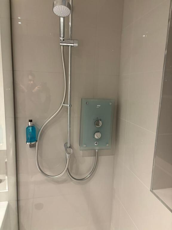 a shower in a bathroom with a shower head at Cathedral Apartment in Lichfield