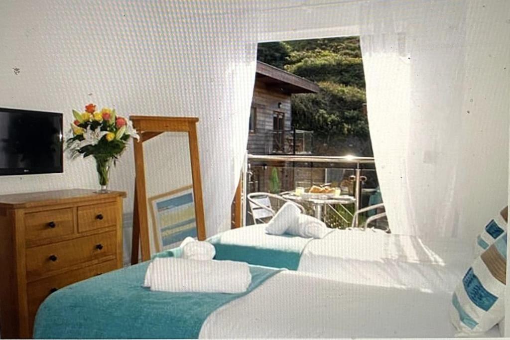 a bedroom with two beds and a window with a view at Valentyne Beach House in Porthtowan