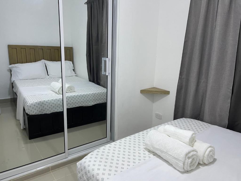 a bedroom with two beds and a mirror at Plataview Apartahotel apt 3A in Monte Plata