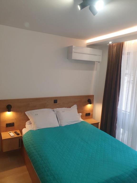 een slaapkamer met een groen bed en een raam bij Apartment ARIA in Velingrad