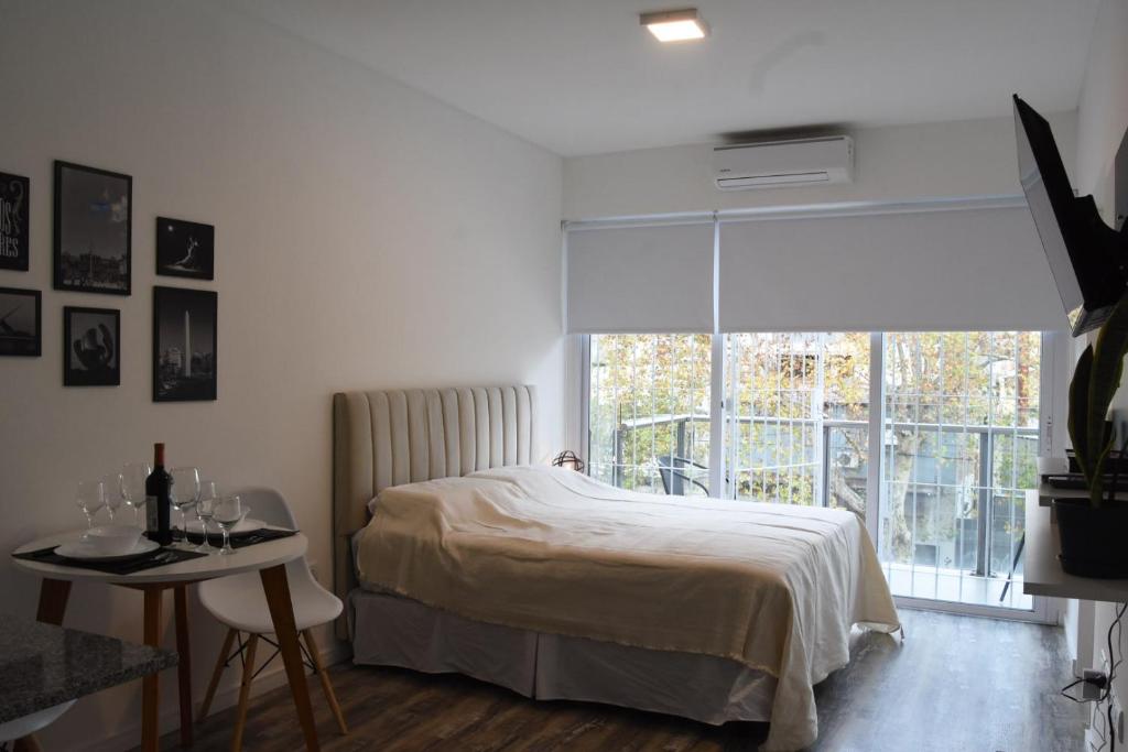 1 dormitorio con cama, ventana y mesa en @juanbjustoapartamento en Buenos Aires