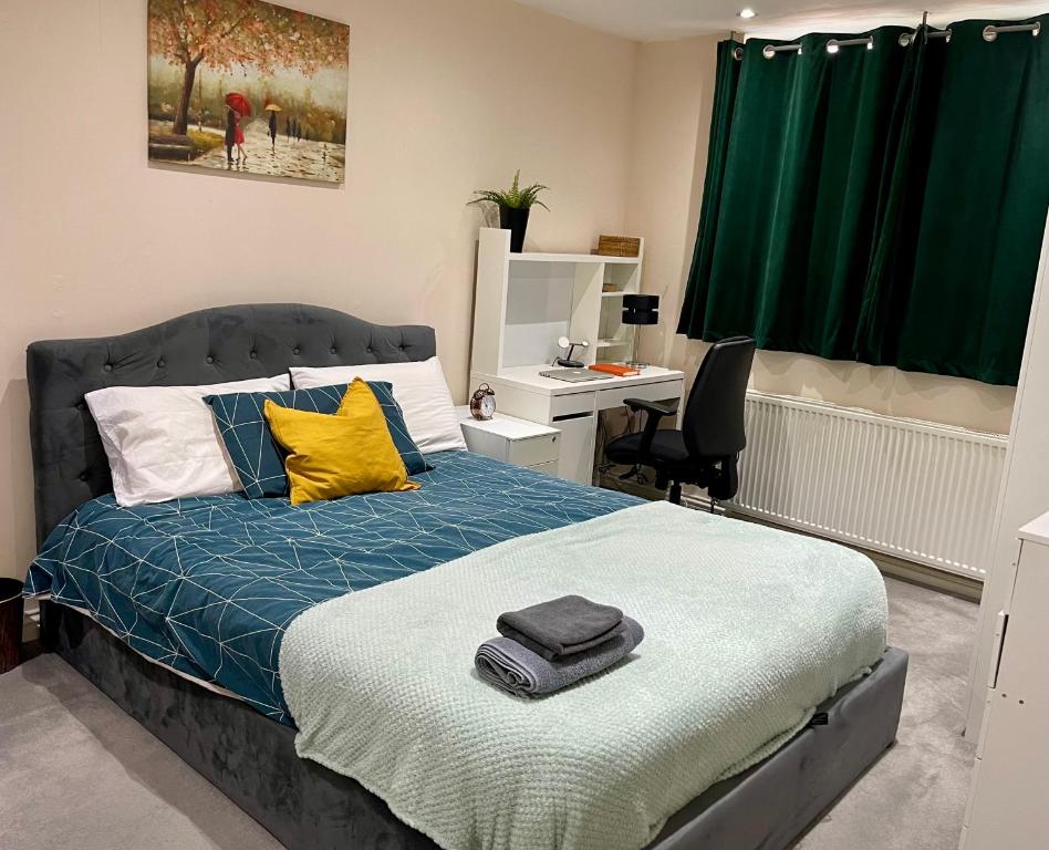 um quarto com uma cama, uma secretária e uma cortina verde em Sudbury Hill Bedroom with Private Bathroom em Harrow