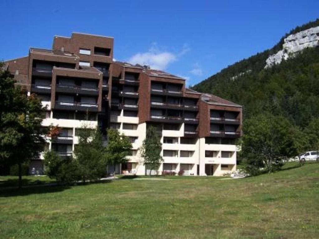 a large building with a grass field in front of it at Résidence Darbounouse - Studio pour 4 Personnes 891 in Corrençon-en-Vercors