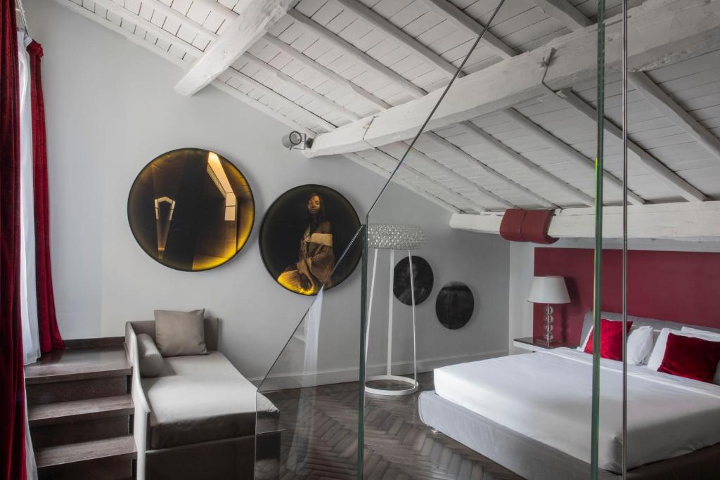 ein Schlafzimmer mit einem Bett, einem Sofa und Spiegeln in der Unterkunft BDB Rooms Margutta in Rom