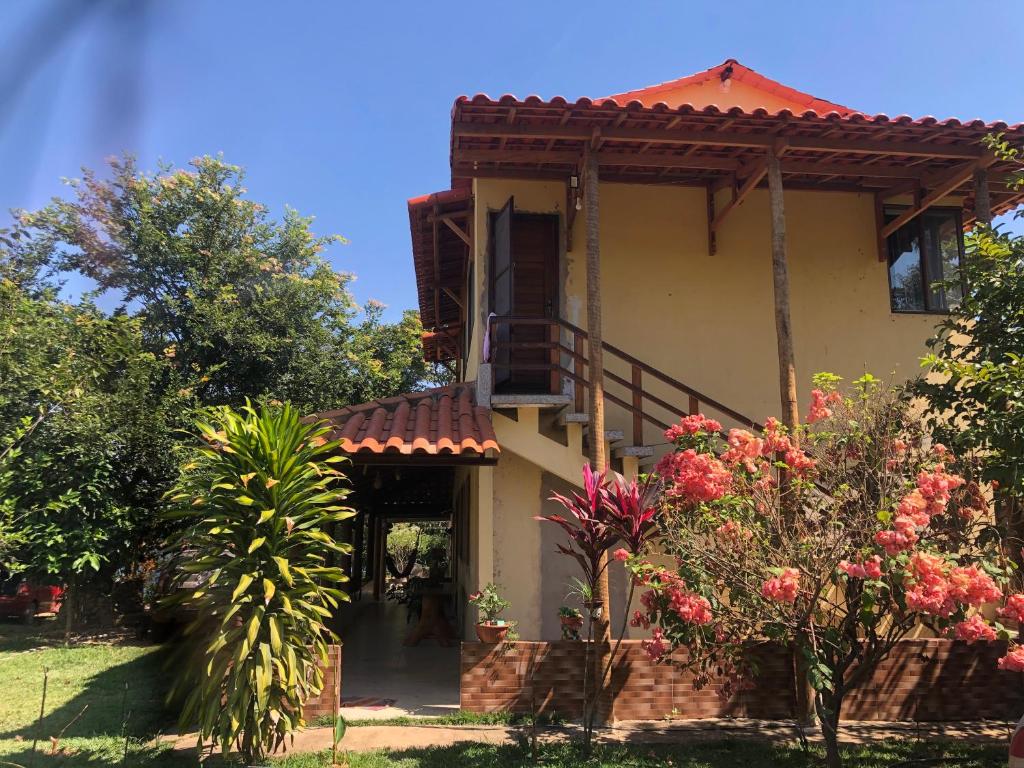 una casa con balcone e fiori nel cortile di Casa Tucunaré a Três Marias