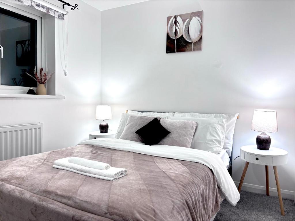 um quarto branco com uma cama grande e 2 mesas em Entire House, Sleeps 5, FreeParking, Work&Leisure em Shenley Brook End