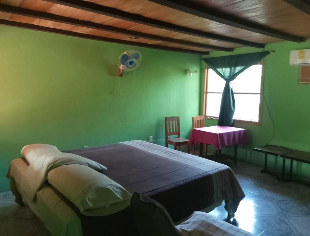 a bedroom with a bed and a table and a window at Hotel El Dorado in Tuxtla Chico