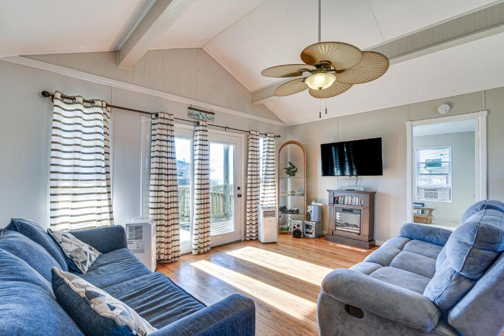- un salon avec deux canapés bleus et un ventilateur de plafond dans l'établissement Surfside Second Row Beach House with Ramp and Deck, à Surfside Beach