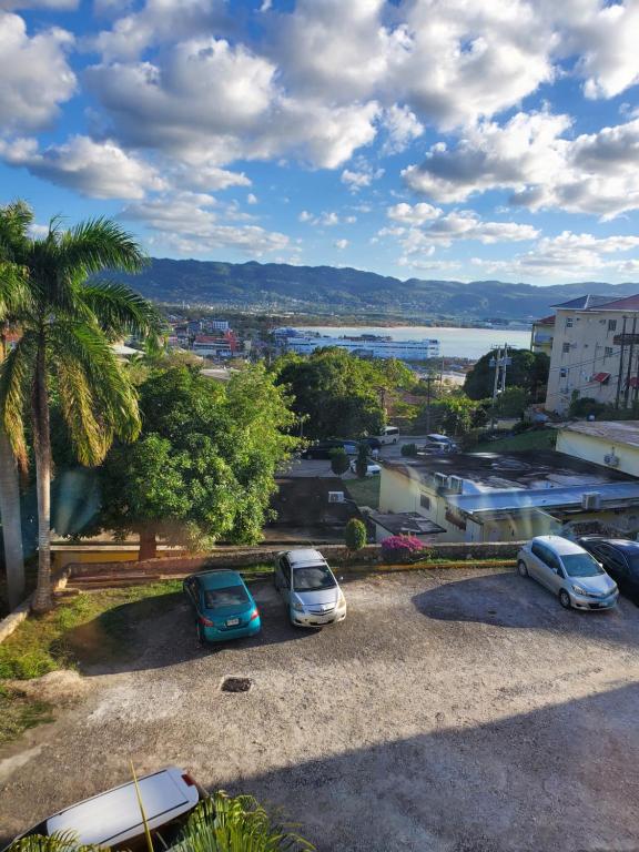 tres autos estacionados en un estacionamiento con una palmera en Exclusive Getaway, en Montego Bay