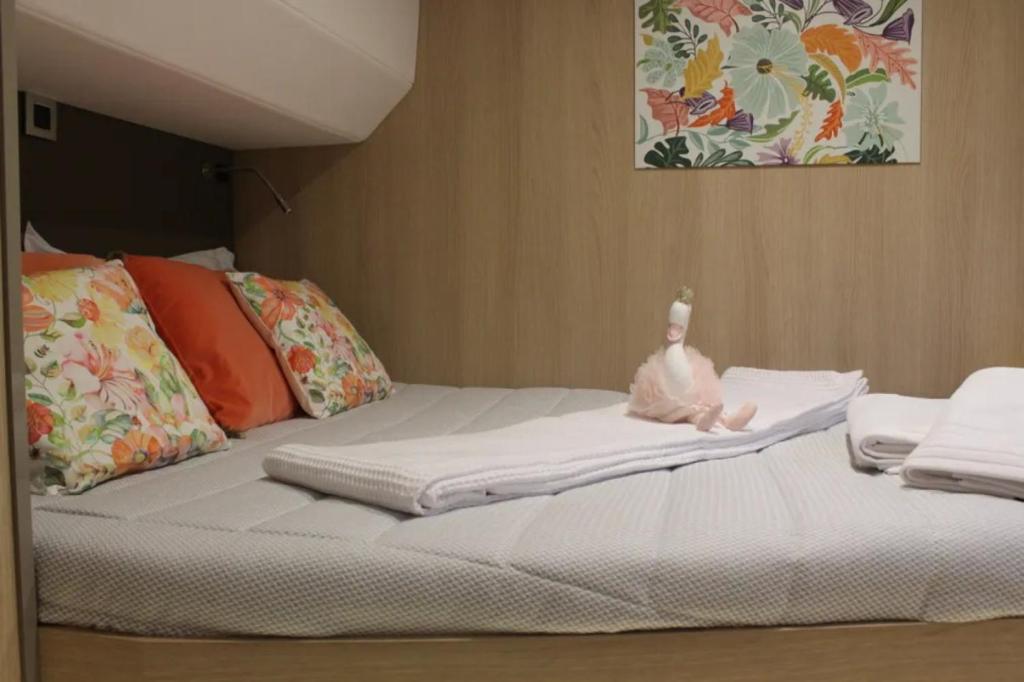 a white bed with a baby bottle on top of it at Catamaran Bali 5.4 in Athens