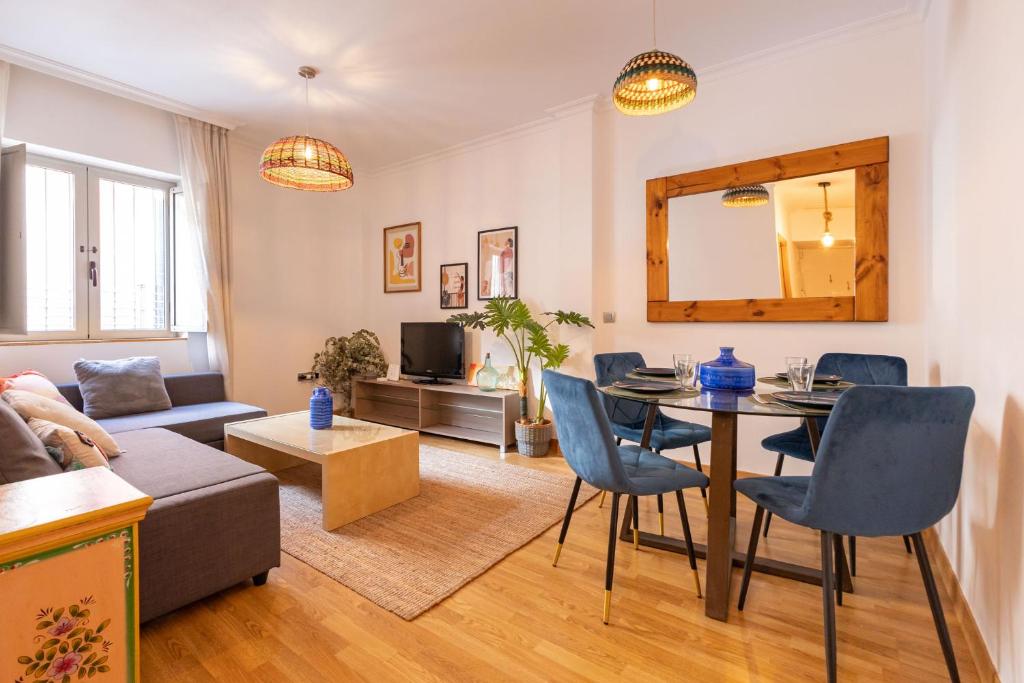 un soggiorno con divano e tavolo con sedie di Charming Apartment at San Bernardo Neighborhood By OUI Sevilla a Siviglia