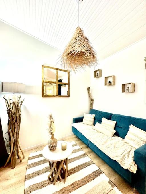 un salon avec un canapé bleu et une table dans l'établissement La Tanière du Bois Flotté, à Nice
