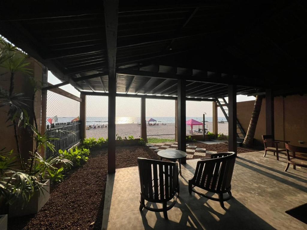 une terrasse avec une table et des chaises et la plage dans l'établissement The Oceanfront Residence, à Ambalangoda