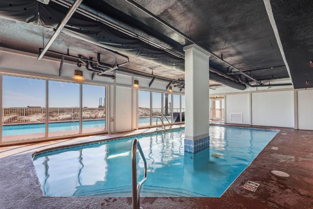 an indoor pool with blue water in a building with windows at Royal Palms 907 in Gulf Shores