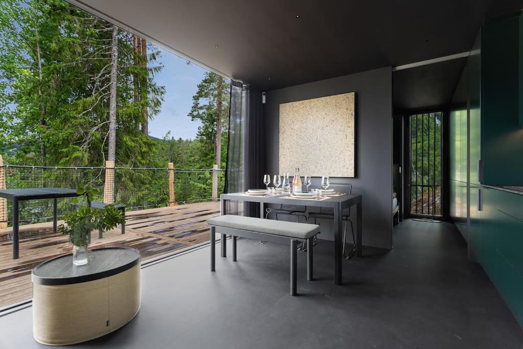 Cette chambre comprend une table, un banc et une grande fenêtre. dans l'établissement Unique Modern Cabin with Views, 