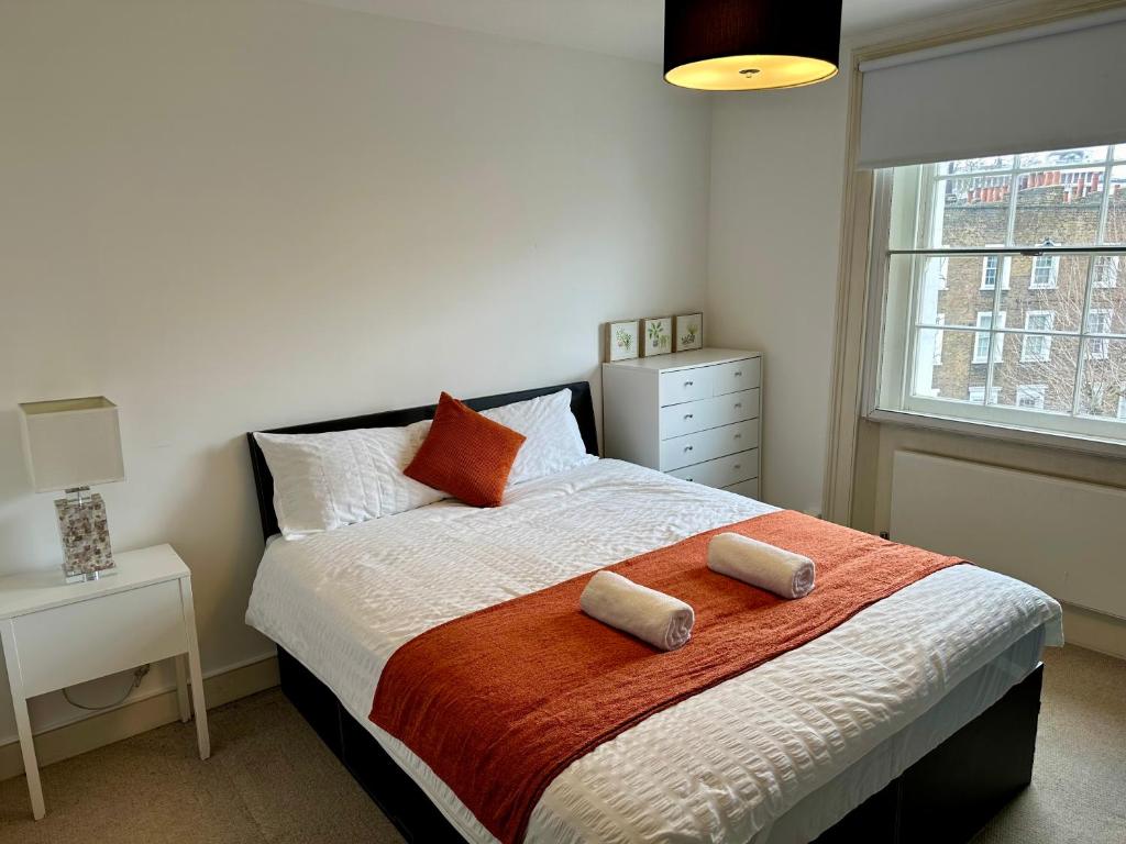 a bedroom with a bed with two pillows on it at Harrington Apartments in Central London in London