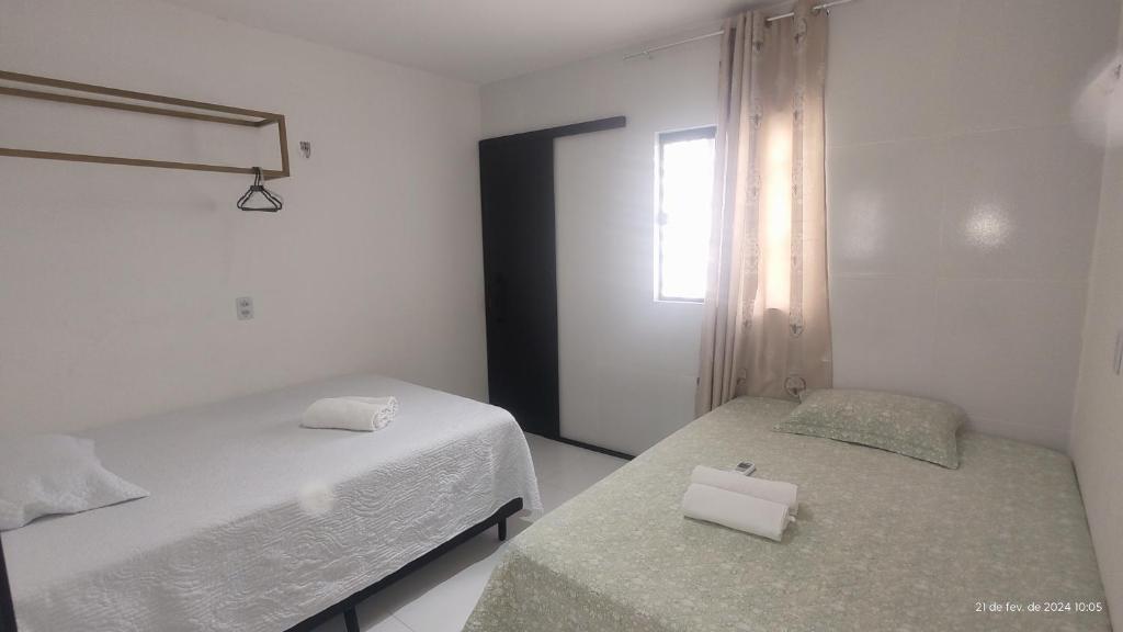 a bedroom with two beds and a window at Casa mobiliada de 2 suítes na R São Lázaro 2367 - 2370 - Jardim Gonzaga in Juazeiro do Norte